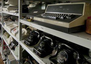 Diverse Sammlungsobjekte wie Schreibmaschine und Wählscheiben-Telefone